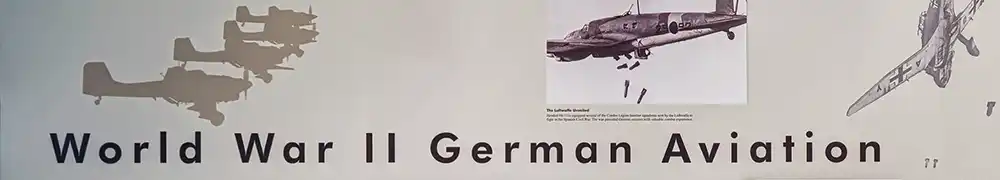 Two large exhibition display panels hung on a silver metal barrier system form a corner exhibition area. Text and graphics are shown on a neutral background.