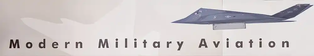 Two large exhibition display panels hung on a silver metal barrier system form a corner exhibition area. Text and graphics are shown on a neutral background.