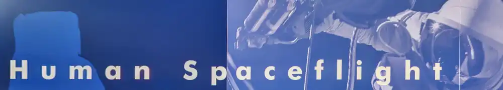 Two large exhibition display panels hung on a silver metal barrier system form a corner exhibition area. White text and graphics are shown on a dark blue background. A large case contains space food, medical instruments, tools, and other small items used by humans during spaceflight.