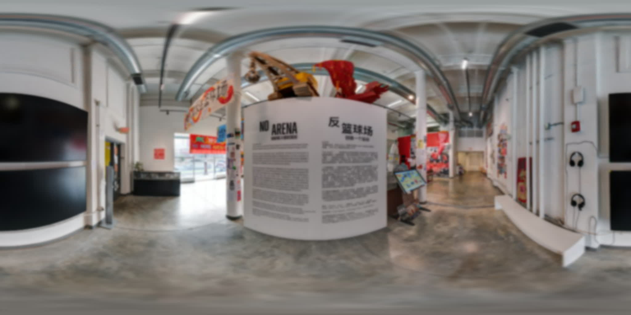Bilingual exhibition introduction surrounded by protest archives, sculptural elements, screens, and listening stations.
