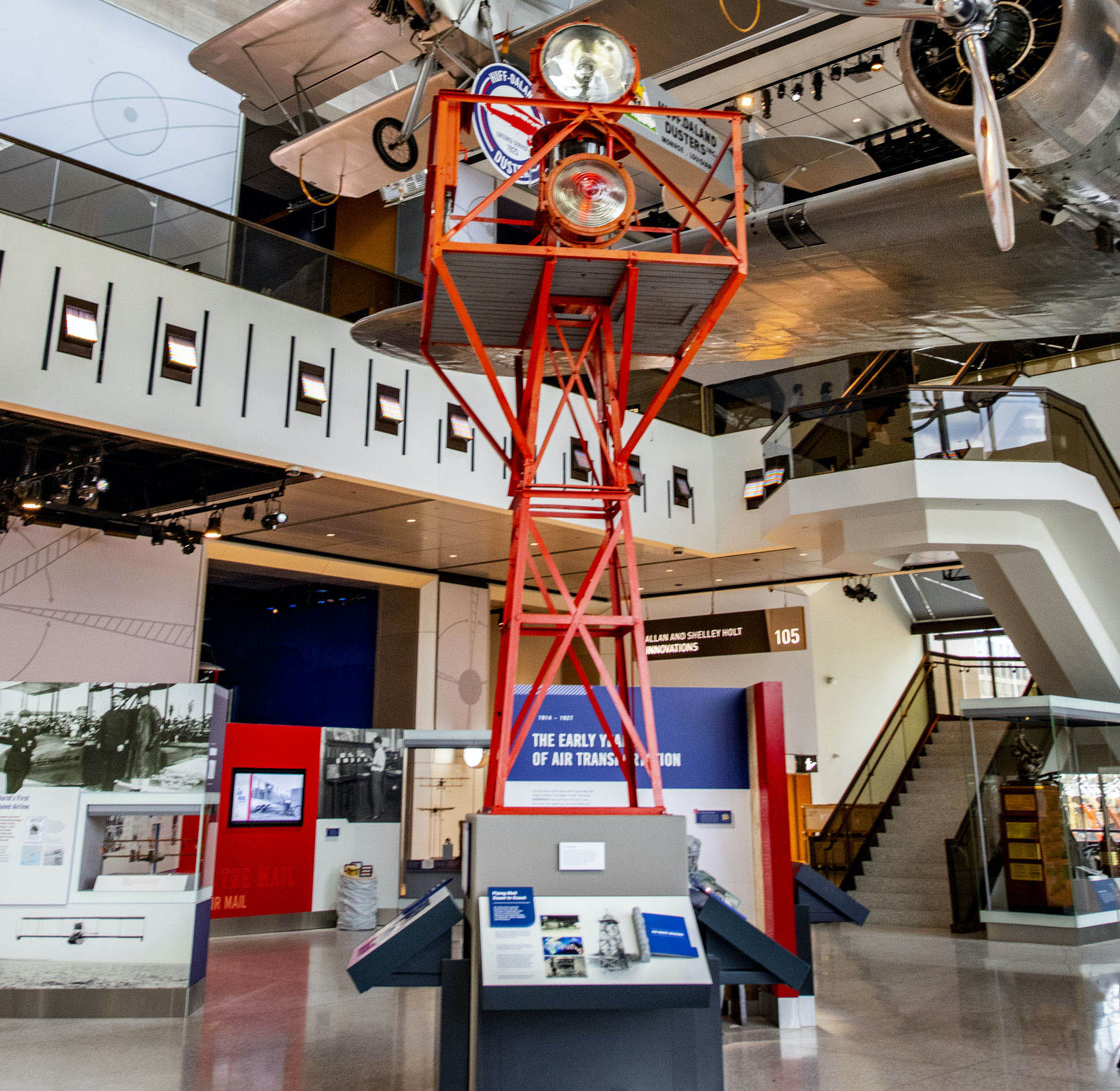 Rotating Fresnel-lens beacon mounted on a red metal airway tower with two course lights and a switch cabinet.