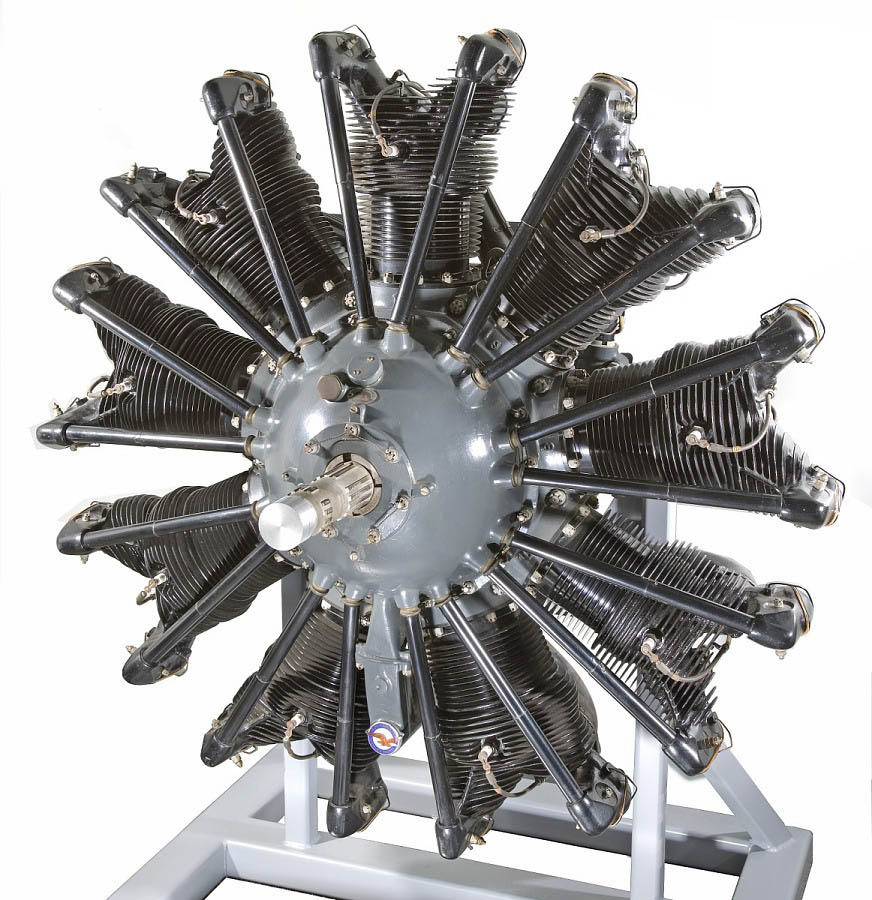 Single-row nine-cylinder radial engine with a gray crankcase, black cylinders, and a central shaft.