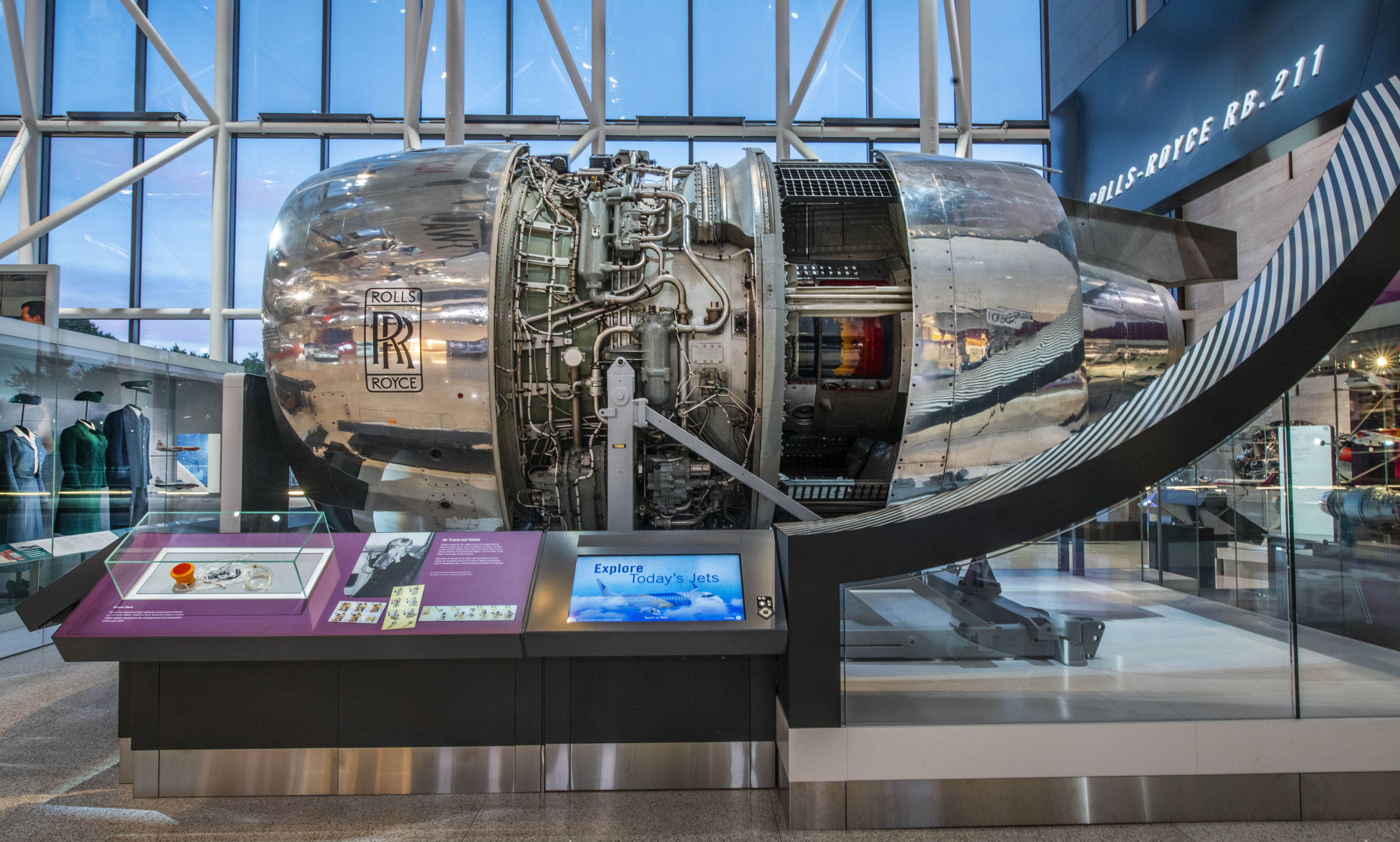 Cutaway three-shaft turbofan with a silver fan cowling and a red-painted hot section.
