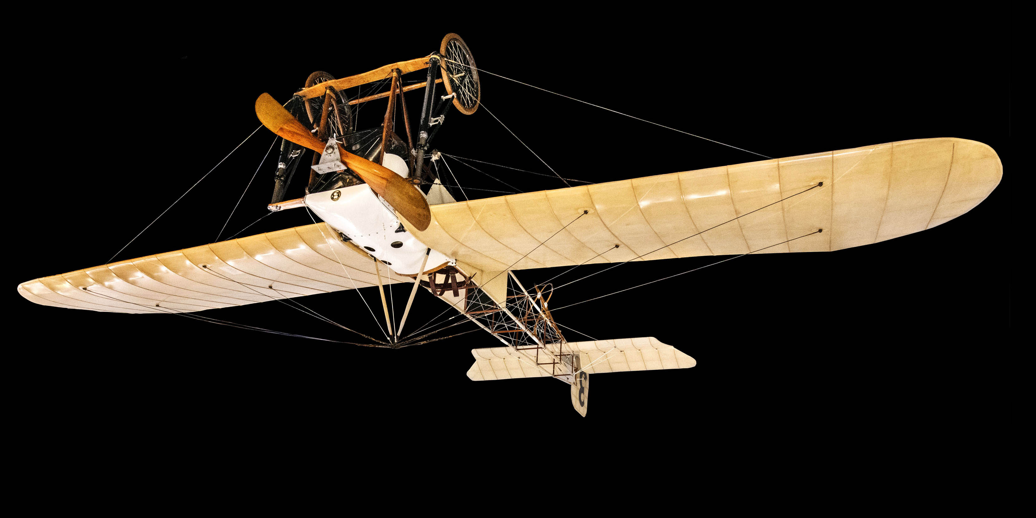 A tractor monoplane with a wooden propeller, open framework fuselage, fabric-covered wings and tail, wing-warping controls, and landing wheels.