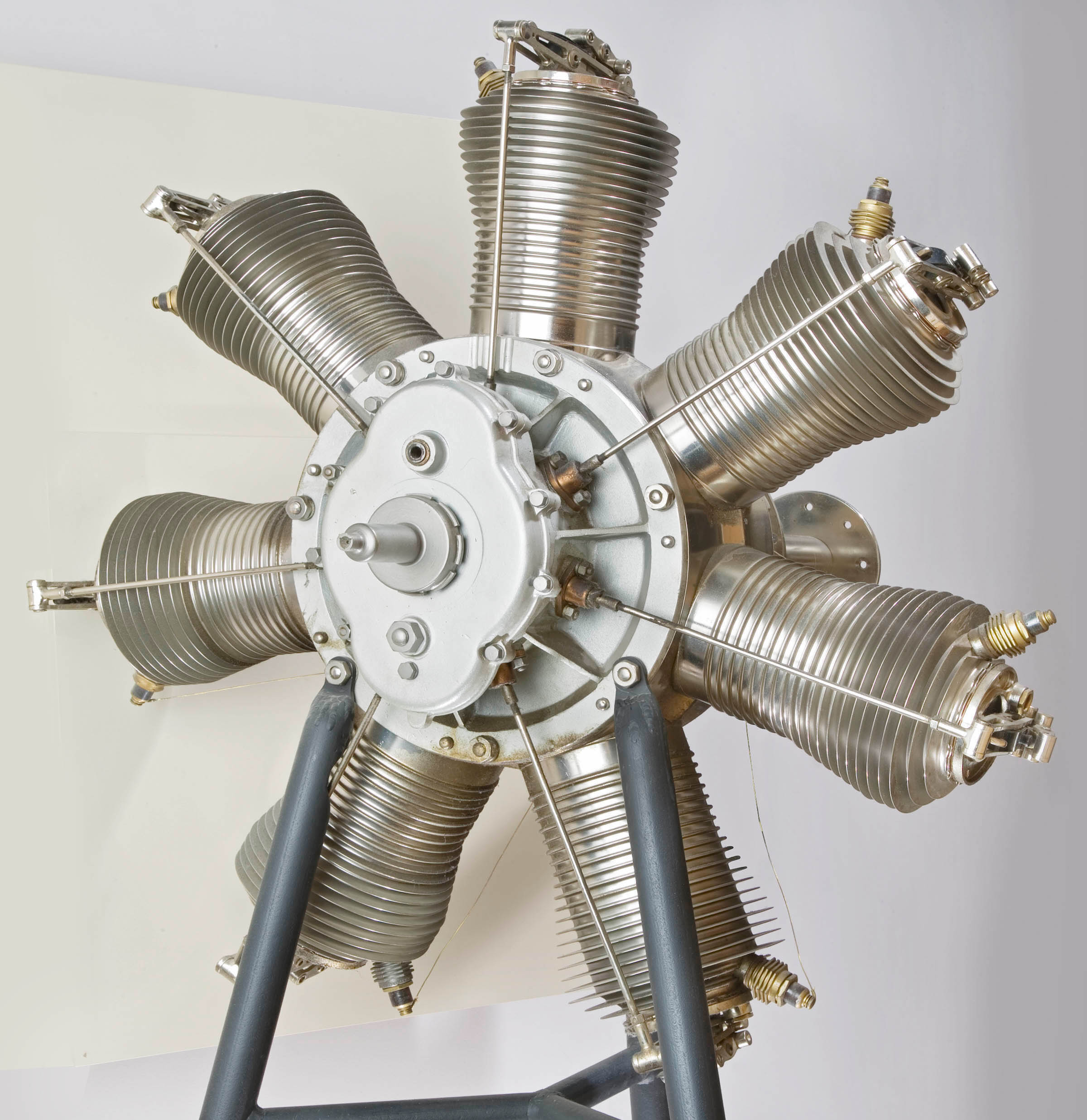 A silver seven-cylinder rotary engine arranged radially around a central propeller shaft.