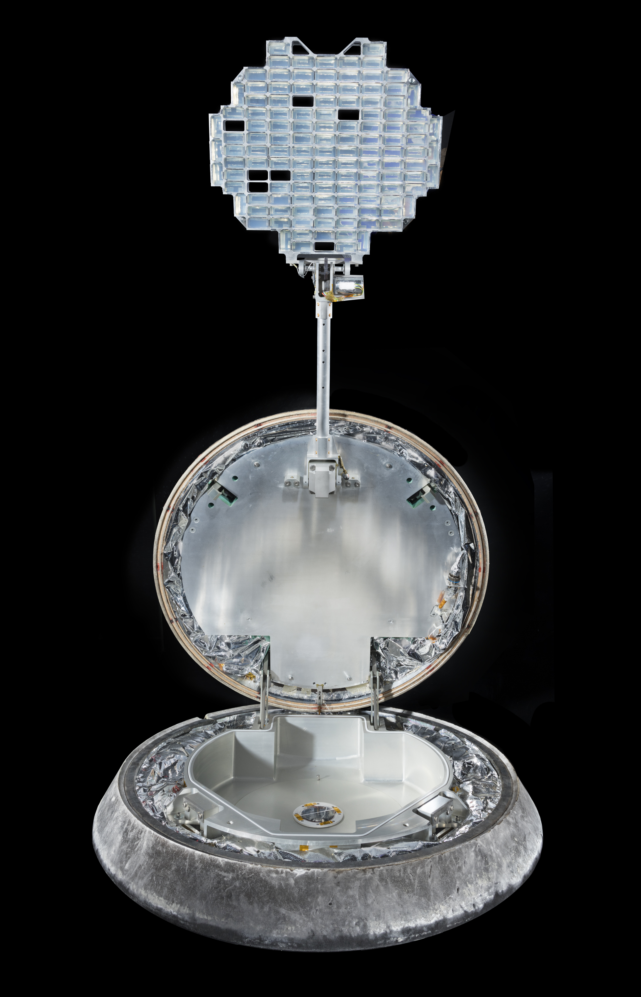 Metal sample-return capsule with a deployed grid holding aerogel tiles used to collect microscopic particles.