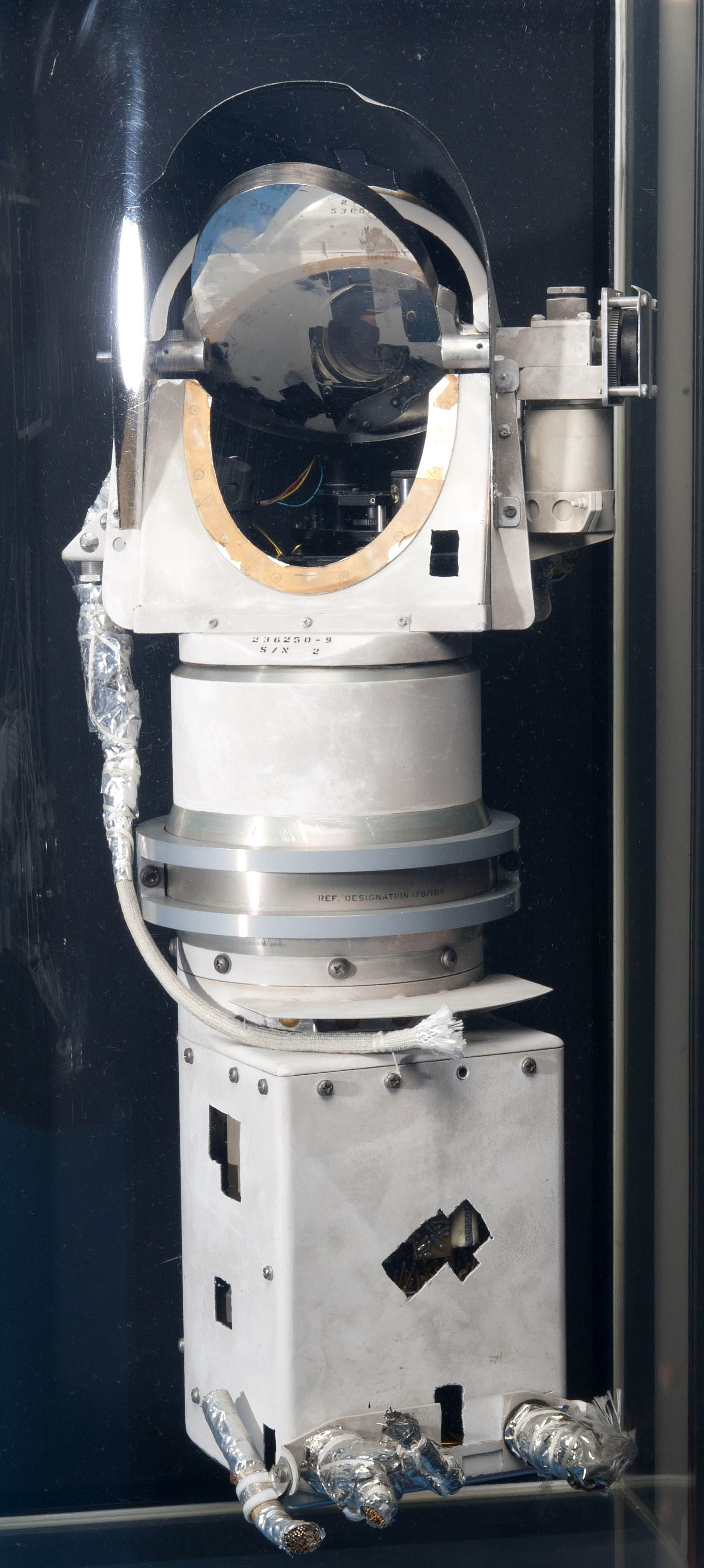 White cylindrical Surveyor camera with a rotating mirror opening and a separate base that permits the instrument to turn.