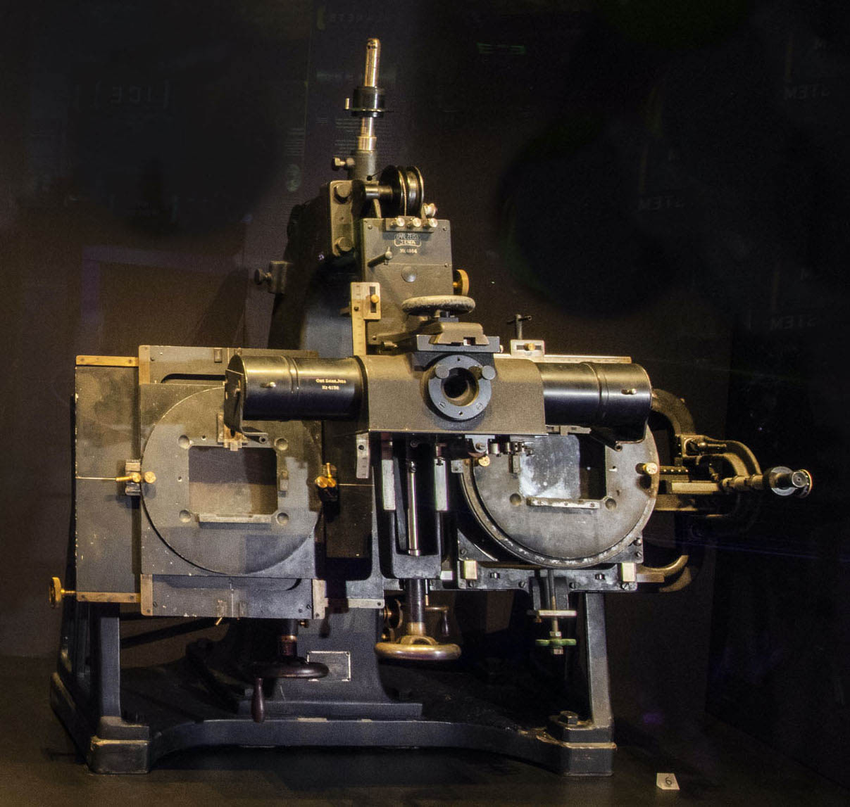 Heavy metal optical instrument with a central eyepiece and two side holders for photographic plates.
