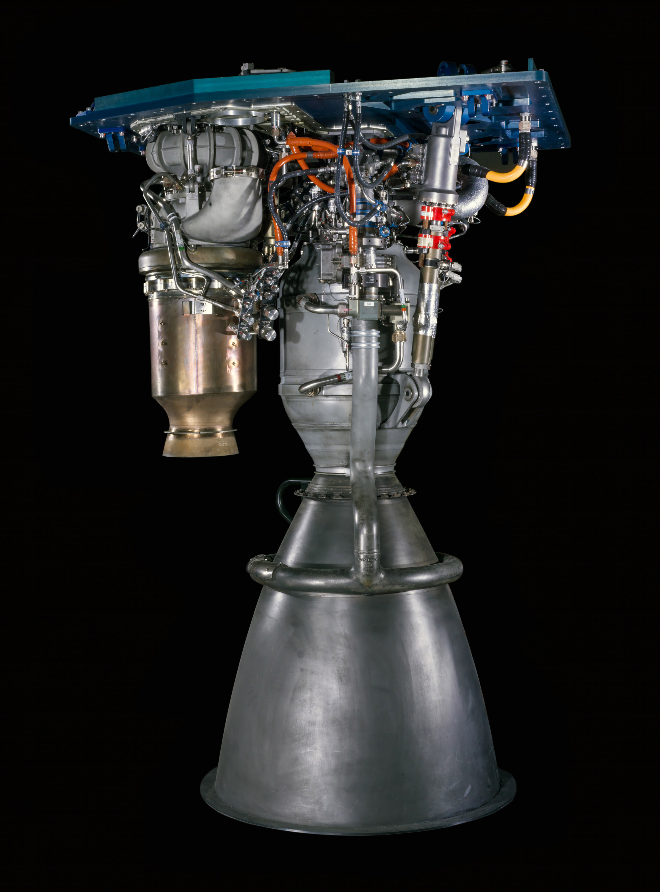 A silver liquid-fueled rocket engine with a downward-facing conical nozzle, combustion chamber, and turbopump.