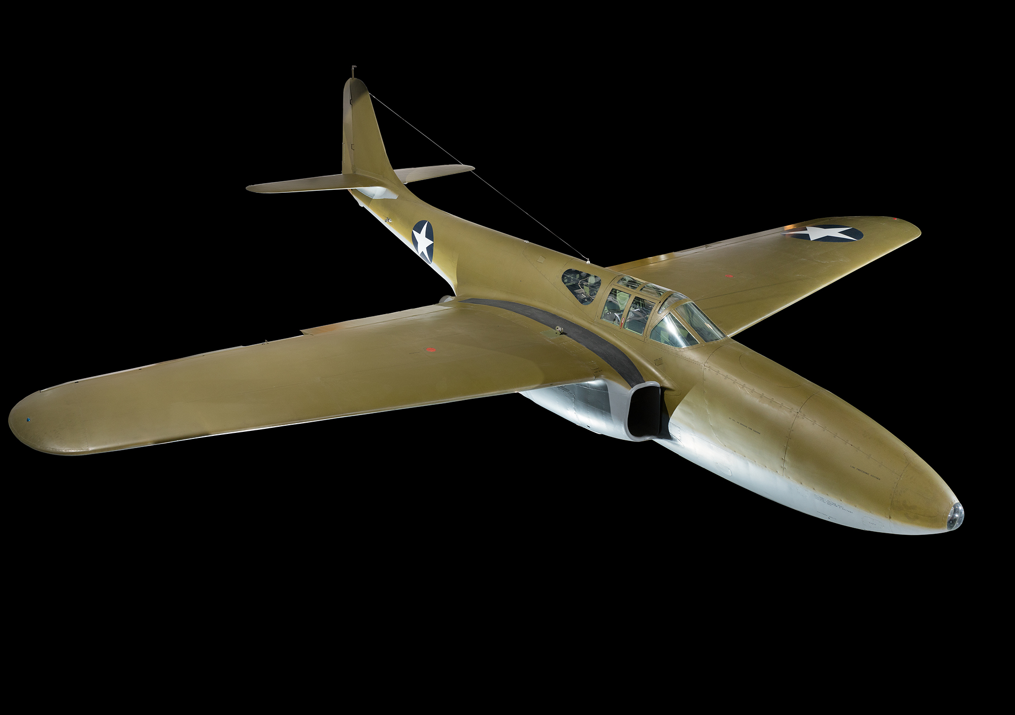 A dull-green, single-seat, twin-engine jet aircraft with an all-metal fuselage and U.S. star insignia.