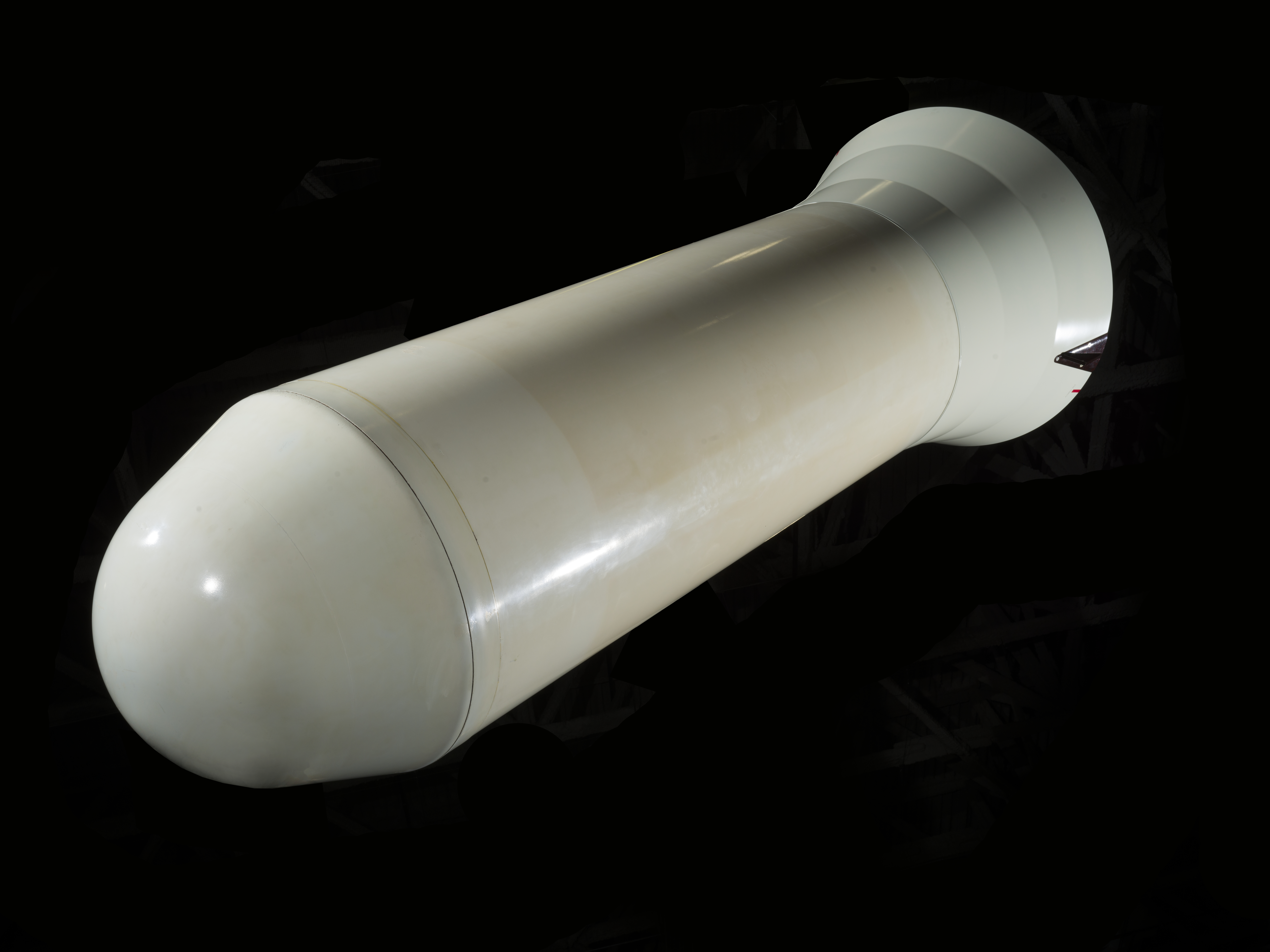 White blunt reentry vehicle with a rounded nose and flared enclosed rear section.