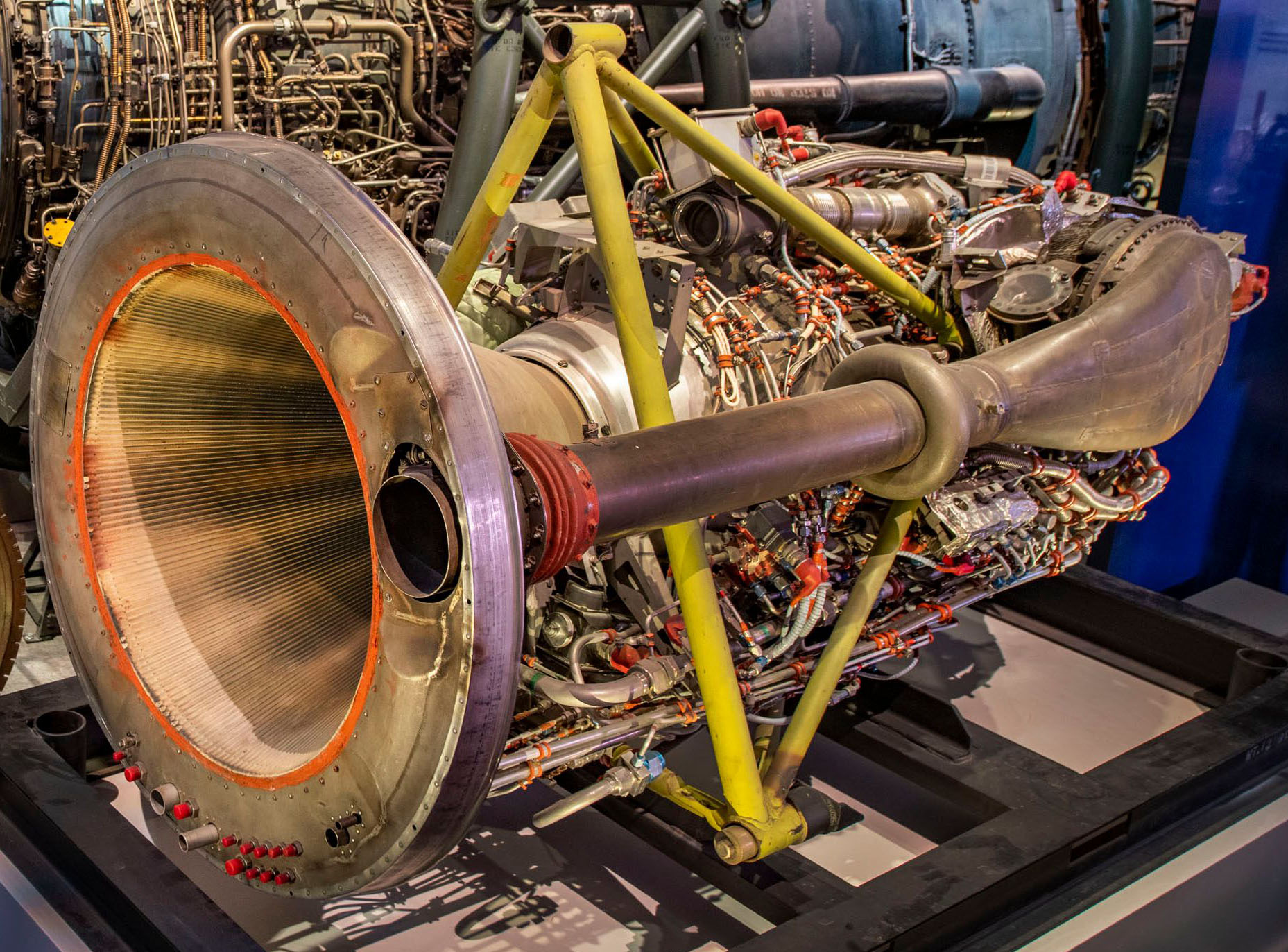 Large exposed rocket engine with dense plumbing and a broad cone-shaped exhaust nozzle.
