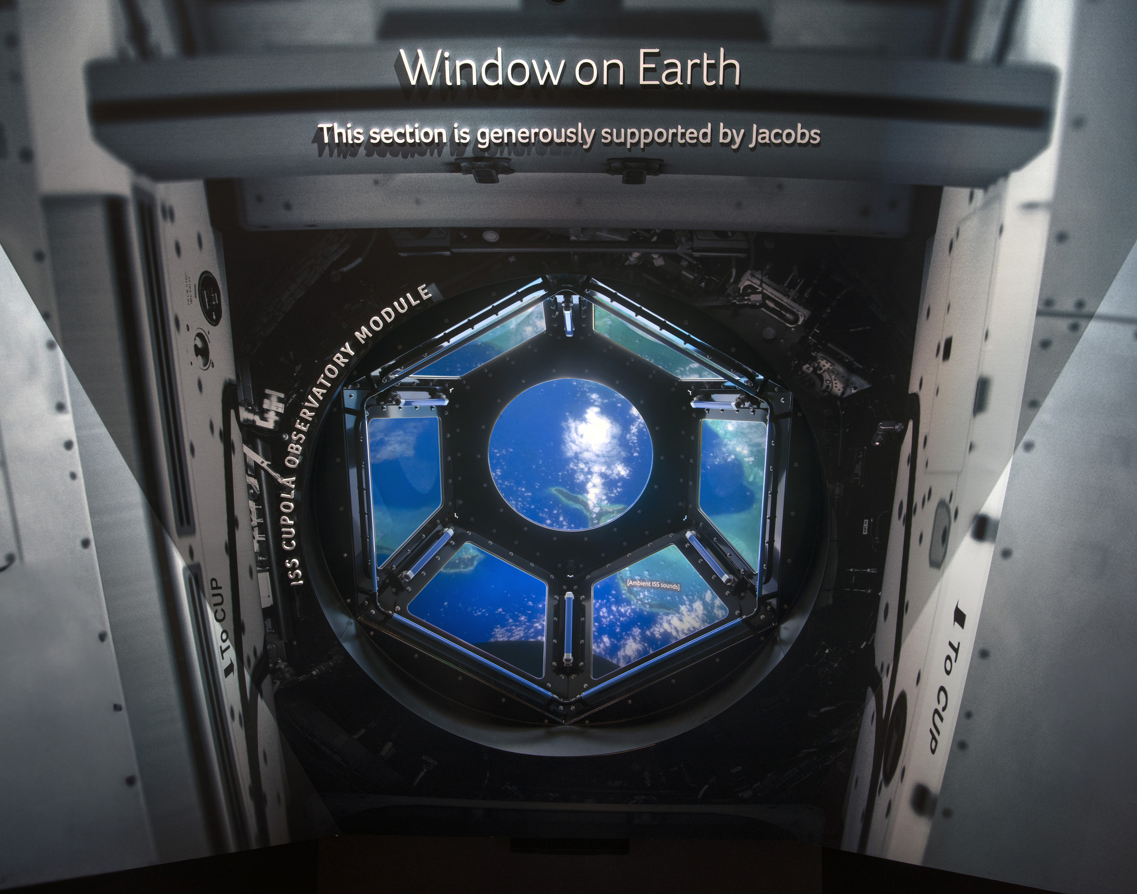 Dome-shaped observatory with seven windows set above a screen showing Earth from orbit.