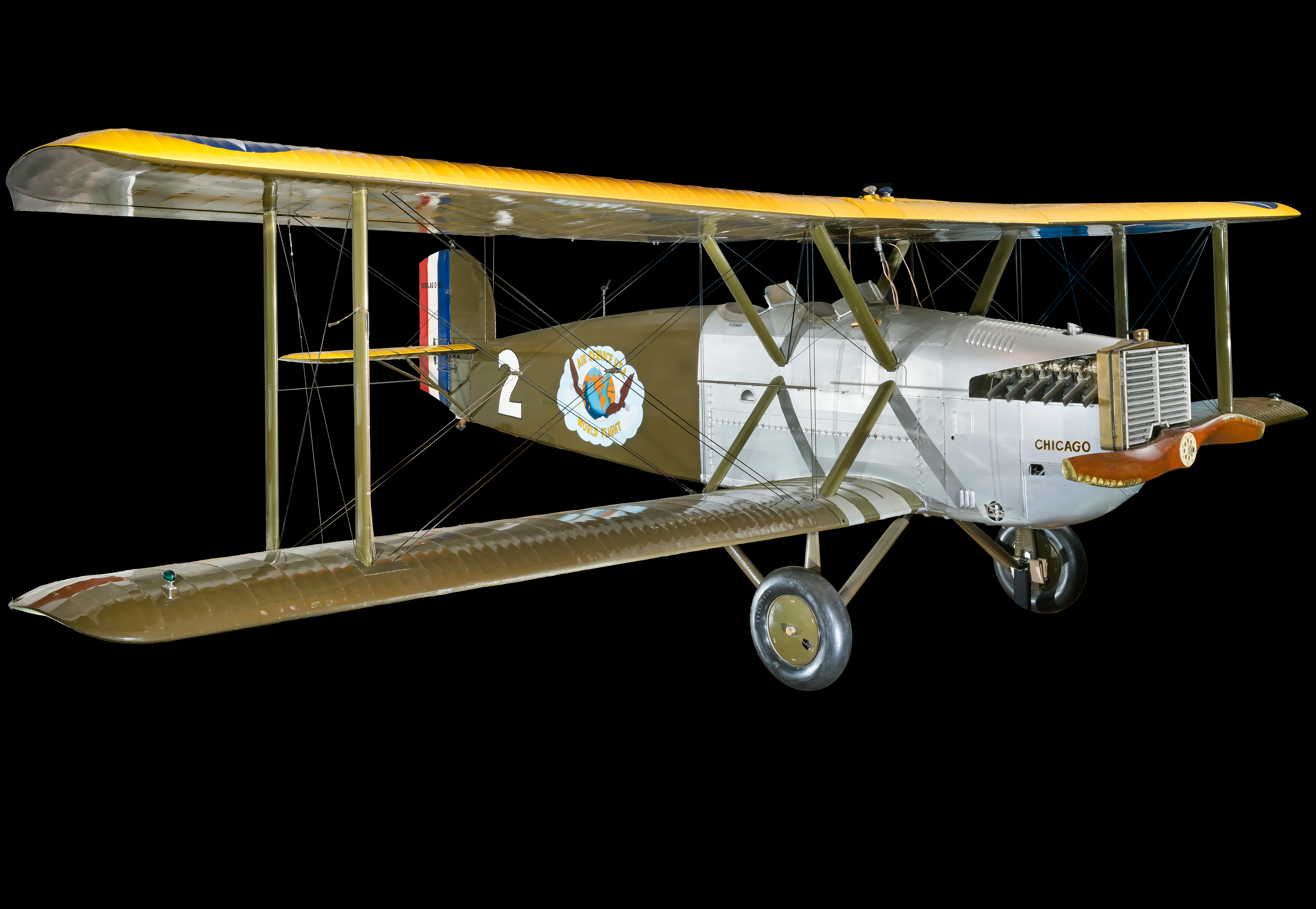 Olive green and silver two-seat, open-cockpit Douglas World Cruiser biplane.
