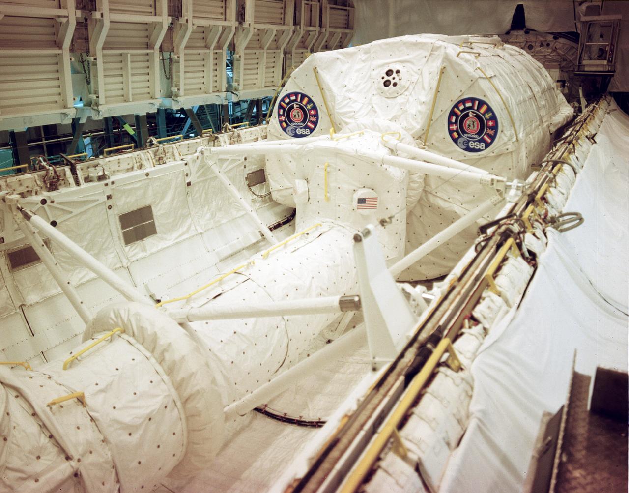 Spacelab 1 and its access tunnel being installed in Columbia for the 1983 STS-9 mission.