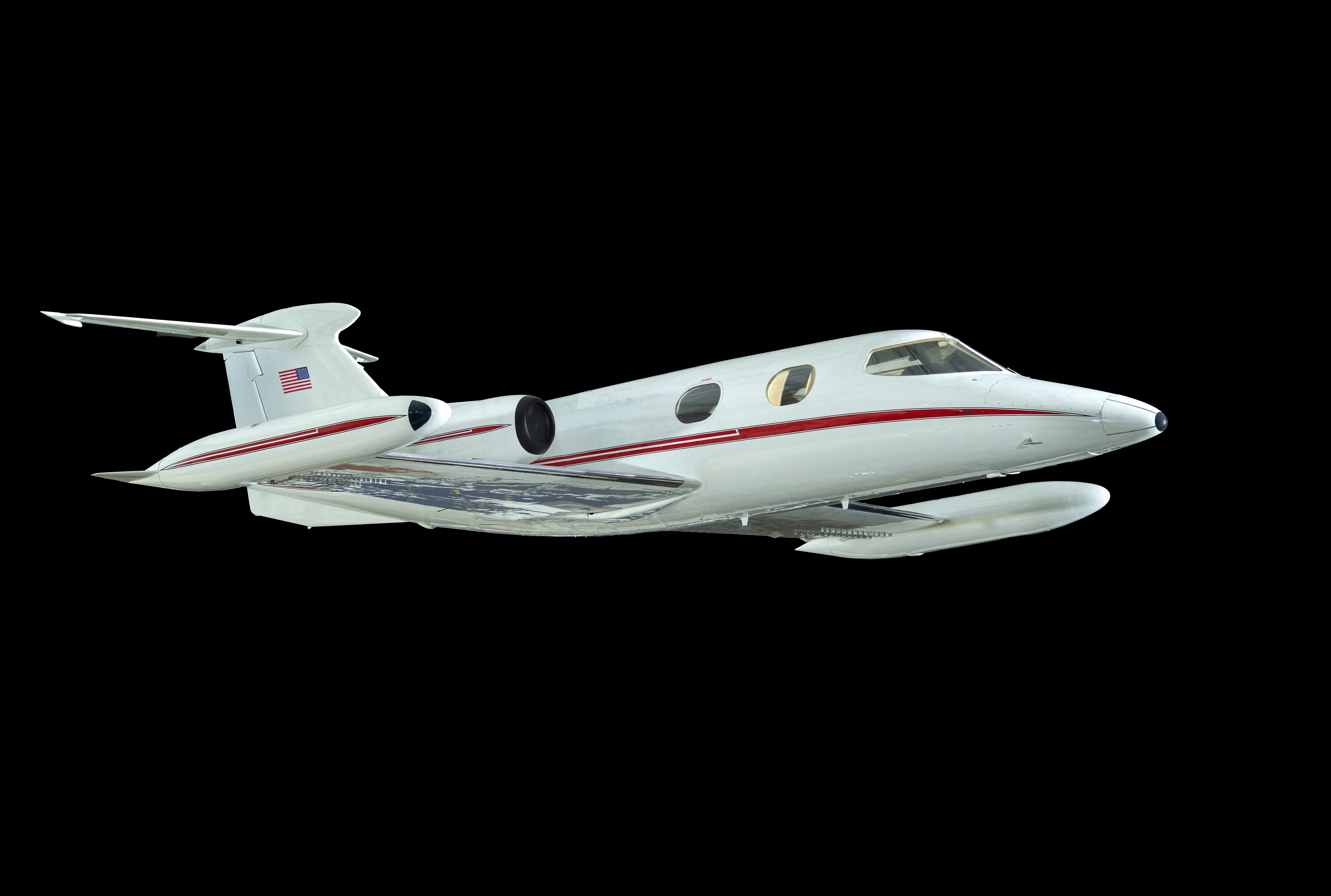 White twin-engine Lear Jet 23 with swept wings, tip tanks, retractable landing gear, and a compact passenger cabin.