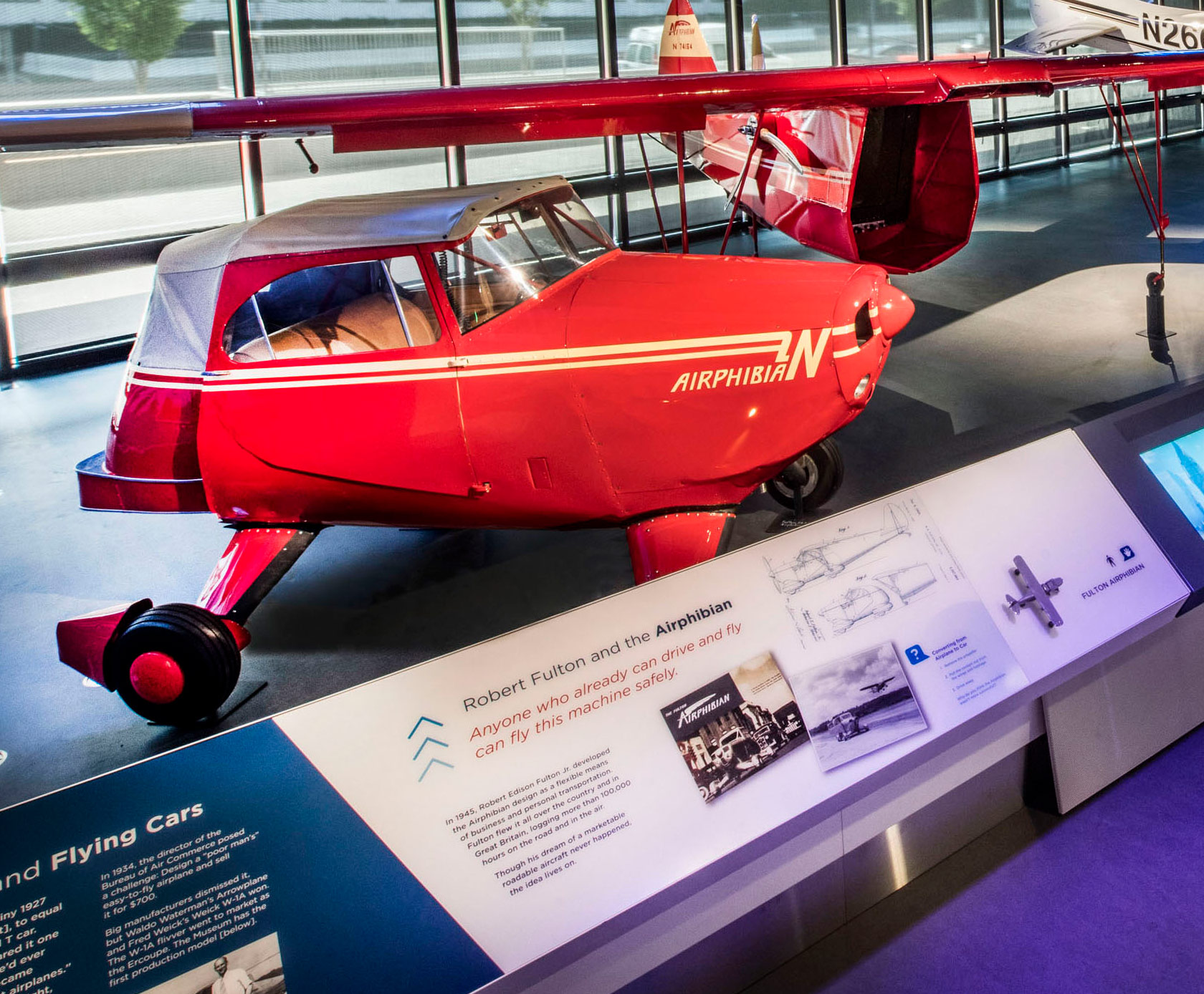 Bright red two-place roadable aircraft whose detachable wings, tail, and propeller convert it into a car.