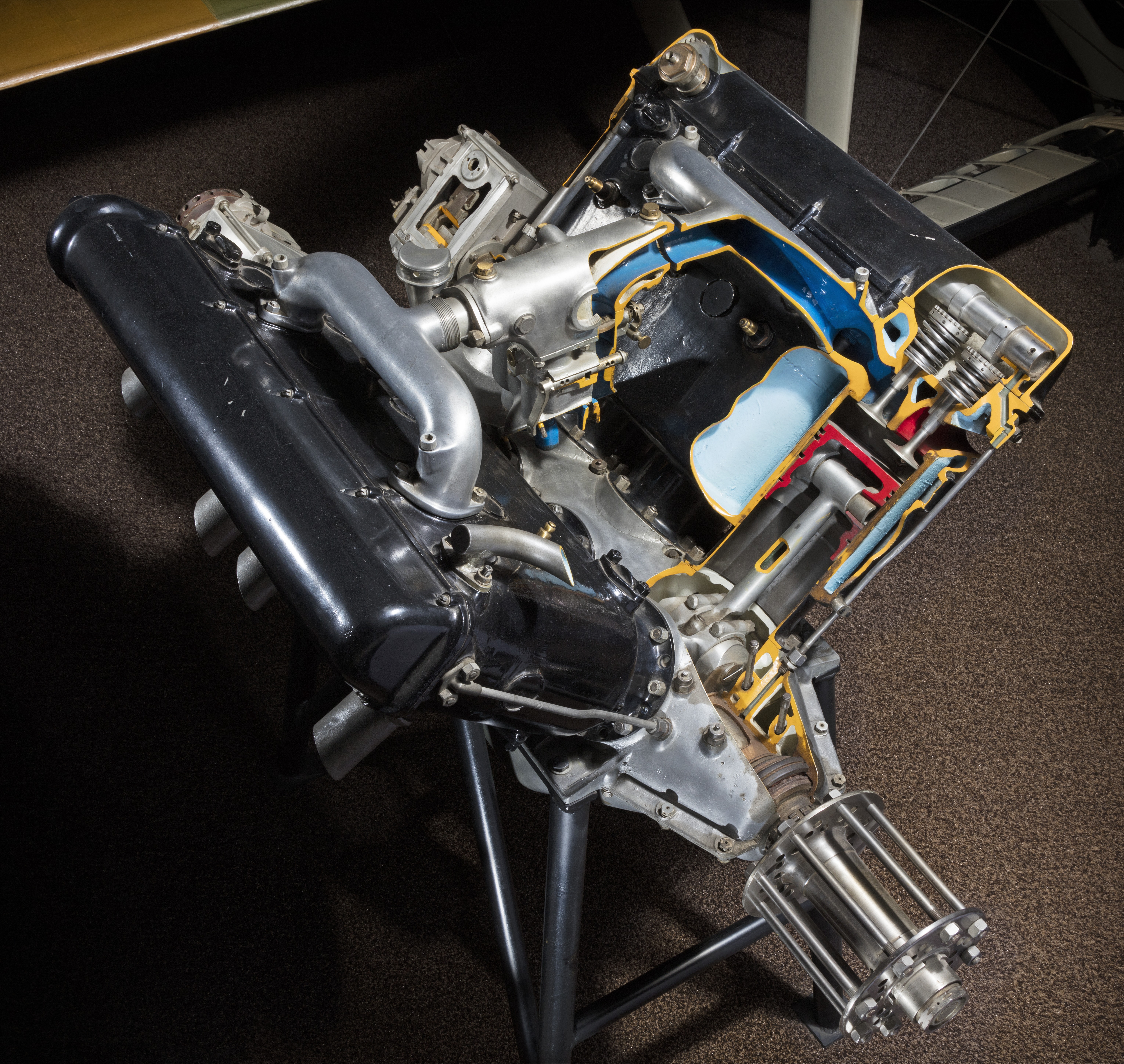 Large metal V-8 aircraft engine with four cylinders on each bank.