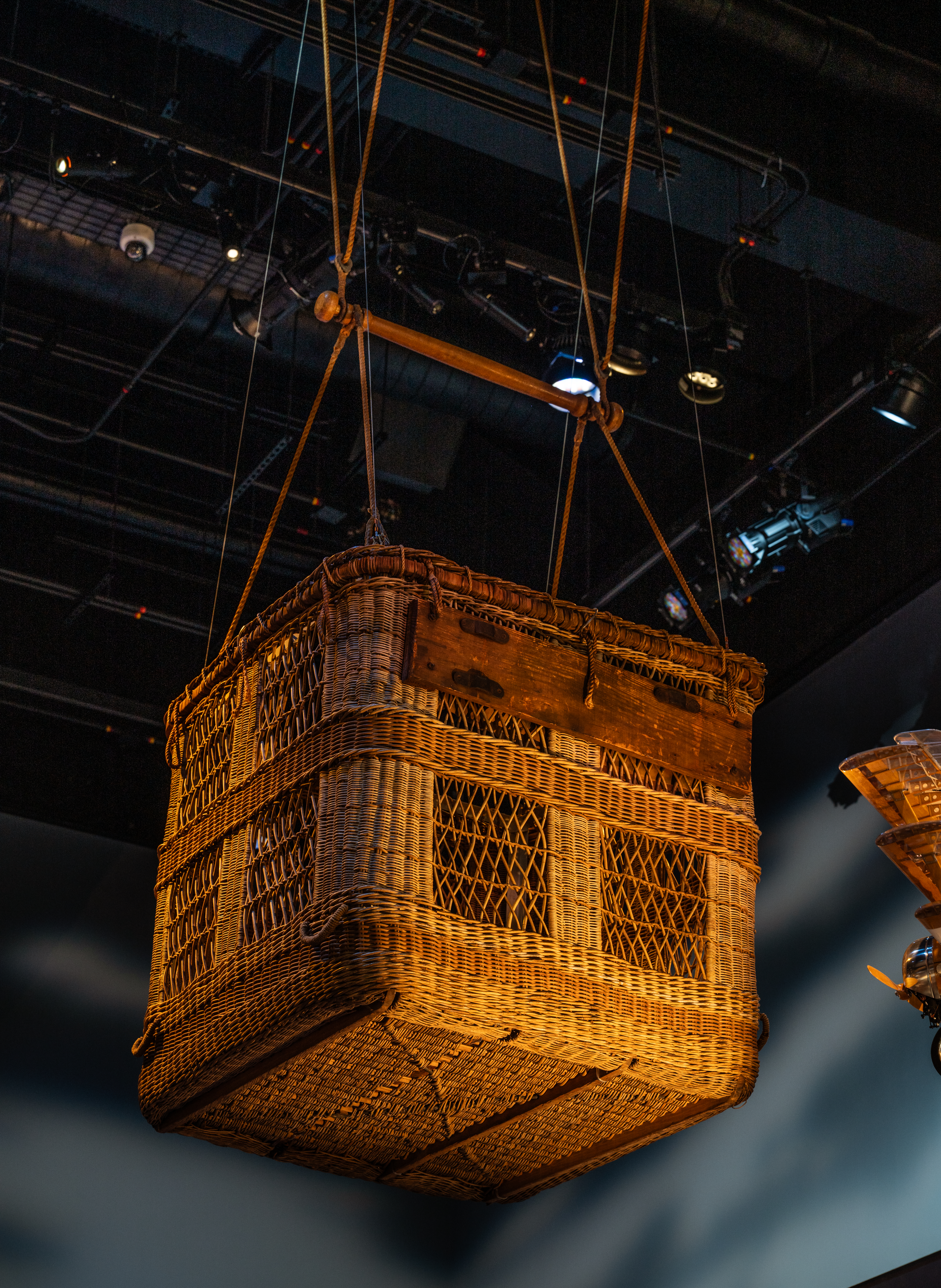 Woven observation-balloon basket suspended with ropes and fittings.
