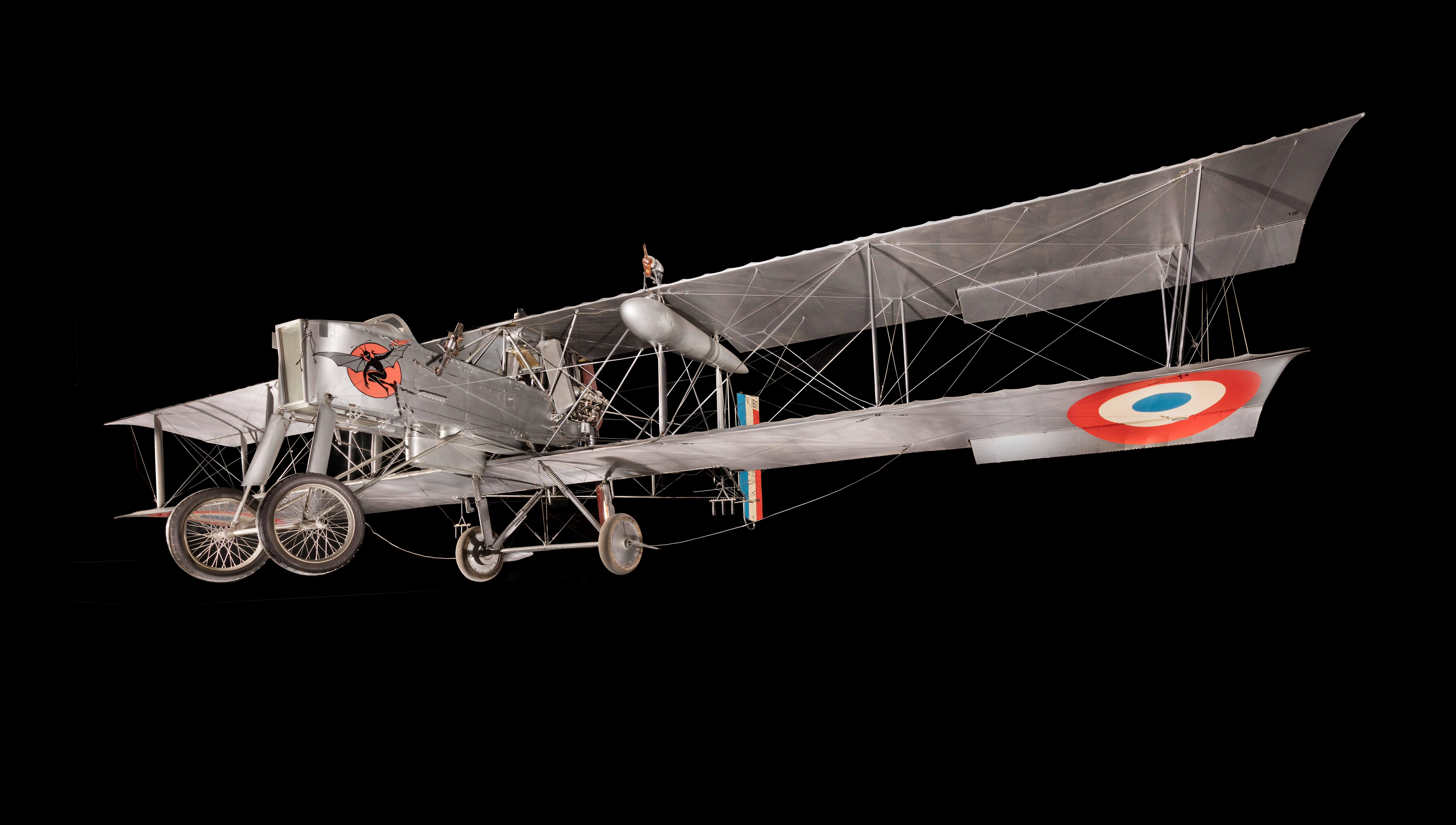 Silver two-seat Voisin Type 8 pusher biplane bomber with a rear-mounted propeller.