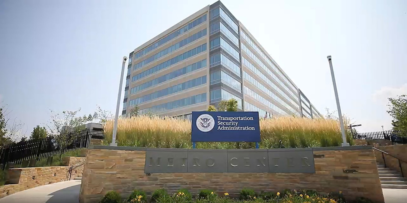 Modern glass-and-stone Transportation Security Administration headquarters viewed from the entrance drive