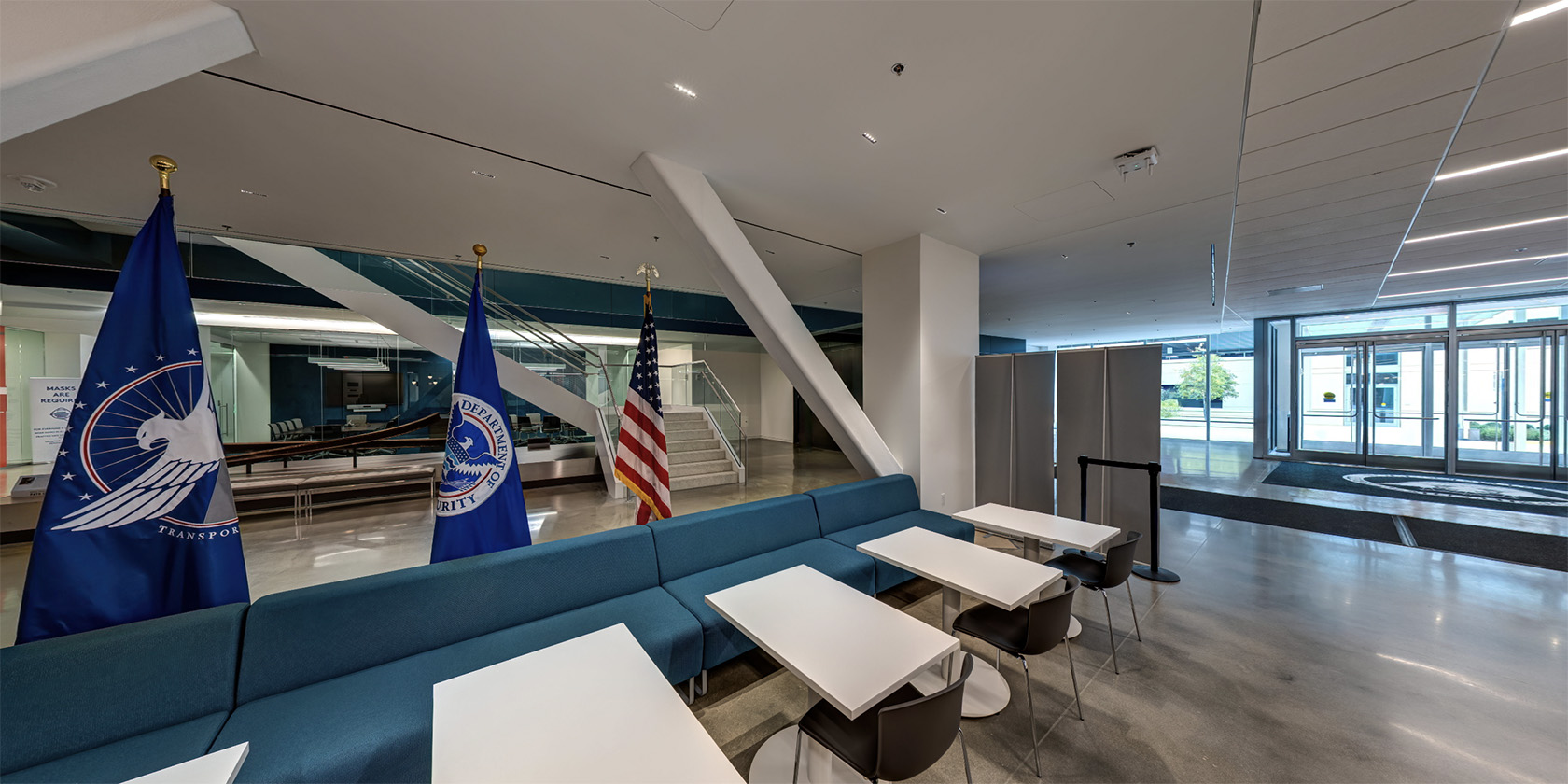 Entrance area leading into Mission Hall with a polished floor, dark exhibit walls, and illuminated displays