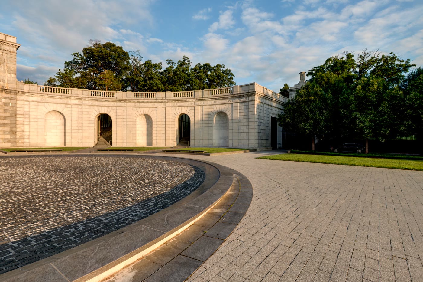 The curving white stone Hemicycle and Court of Valor in warm early-morning light
